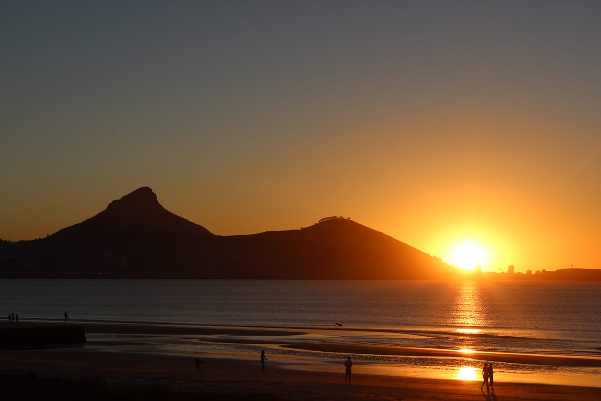 Fernreisen mit Kindern wohin? Beliebte Urlaubsziele für Familien – Südafrika, Sonnenuntergang am Strand von Milnerton