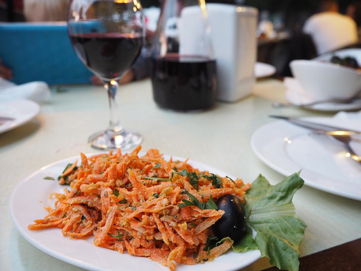 Georgischer Salat mit geraspelter Möhre und einem Glas georgischen Wein